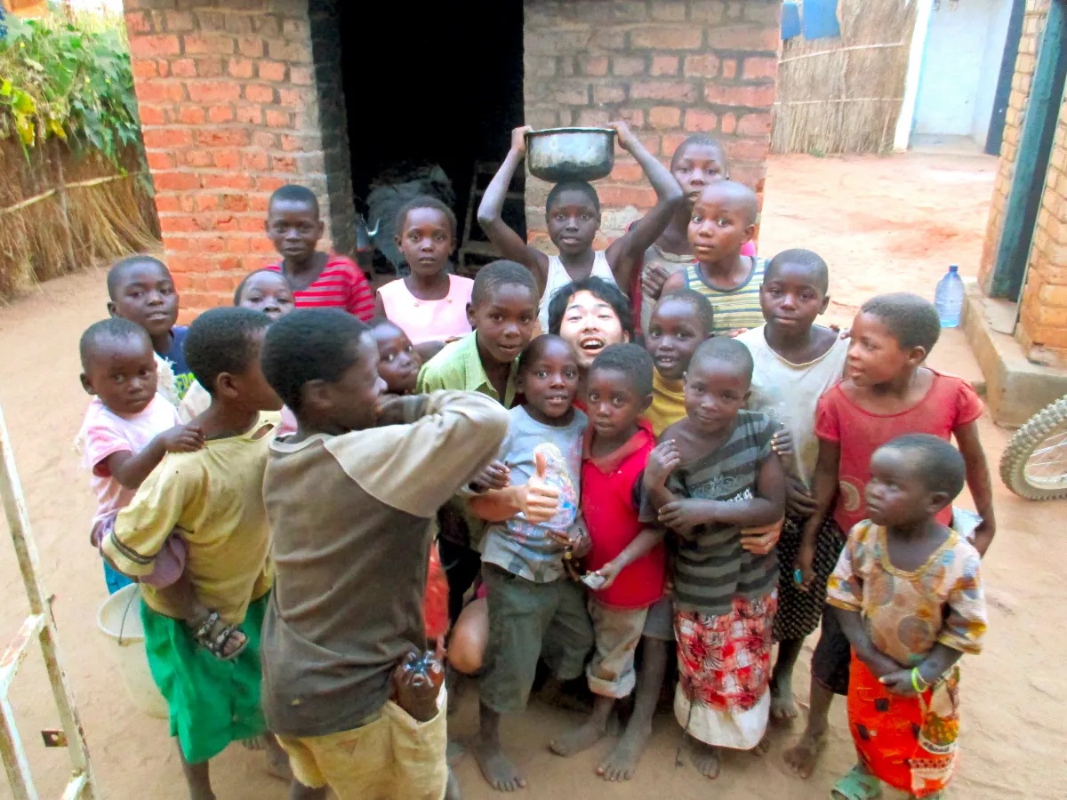 ​笑顔で過ごすアフリカ・マラウイの子ども達と庄田さんの画像