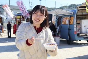 模擬店の料理をもって微笑む女性
