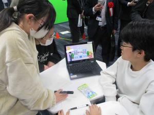 パソコンに向かって打ち合わせをする児童