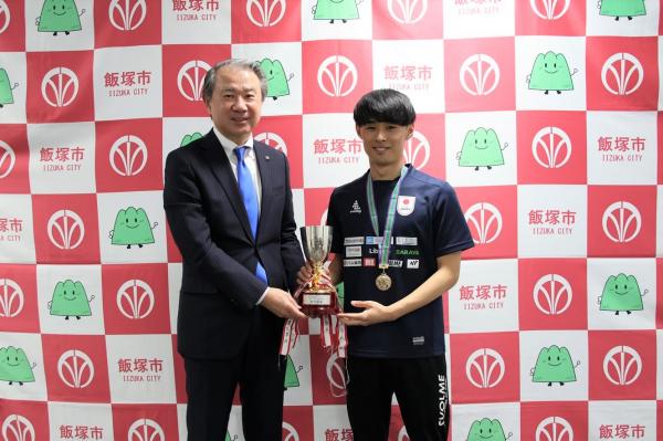 優勝トロフィーを持つ表敬者と市長