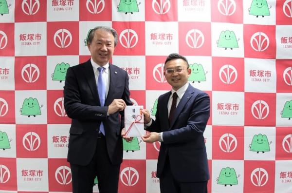 目録を武井市長に手渡す表敬者