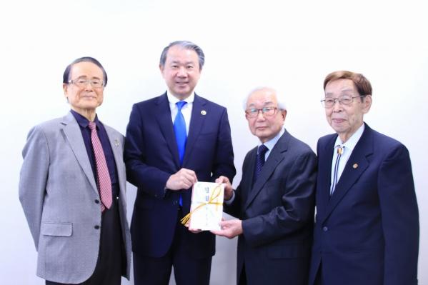 目録を手にする武井市長と男性合唱団「としとらーズ」様