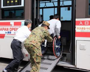 バスへ車いすの誘導支援をするボランティア
