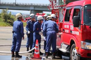 消防車を使ったホース連結を行う消防団員