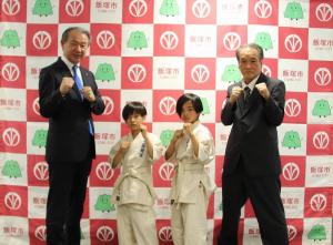 空手の構えをとる武井市長、和田莞慈(かんじ)さん、和田寧翔(ねいと)さん、工藤浩館長
