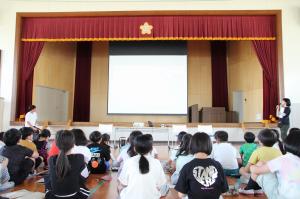矢野選手と車いすテニス協会のスタッフの話を座って聞く飯塚小学校4年生