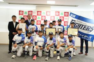 チームの旗とともに写真におさまる5、6年生14人と父母会長、市長、教育長