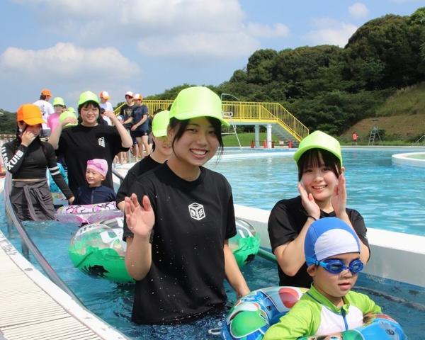 プールに入り笑顔の児童とボランティアの皆さん