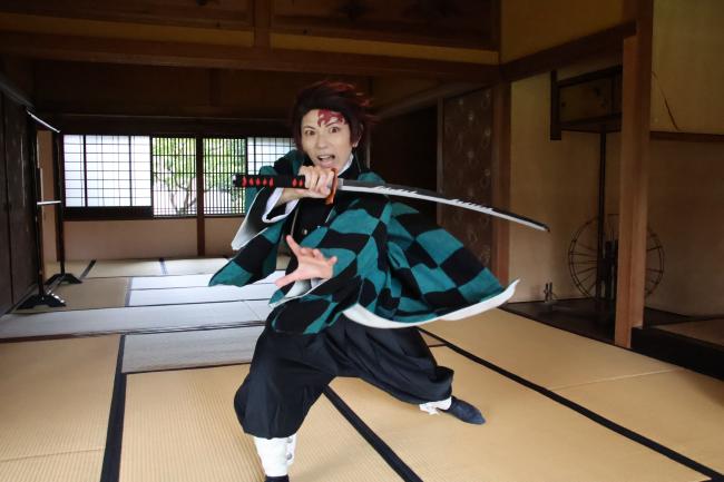 旧伊藤伝右衛門邸内で躍動感のある写真を撮影しているコスプレイヤー