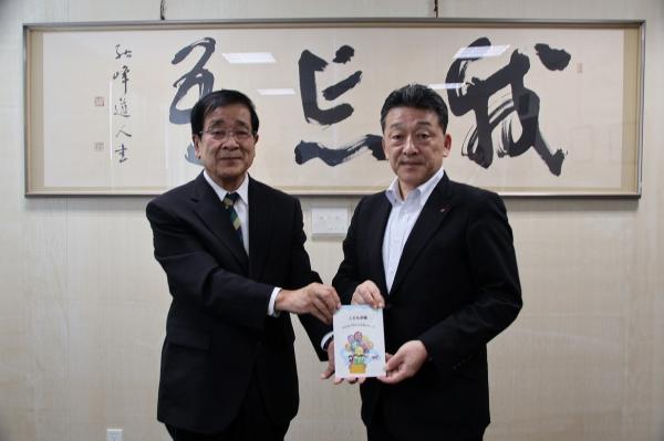 公益財団法人日本公衆電話会から冊子「こども手帳~みんなで守ろう社会のルール~」を受け取る桑原教育長