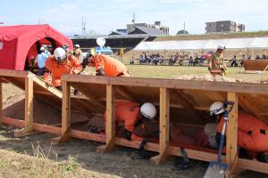 建物をチェーンソーで破壊し、閉じ込められた被災者を救助する消防吏員