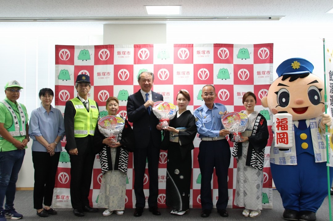 うちわ贈呈式で写真に収まる武井市長、飯塚警察署長含む関係者たち