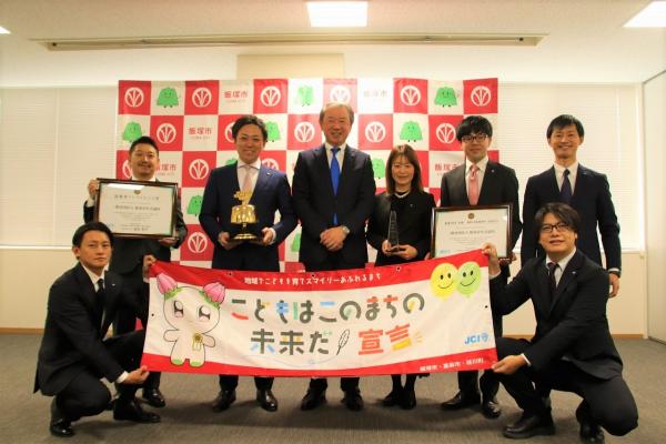 12月17日に市役所で武井市長と喜びの報告を行う一般社団法人飯塚青年会議所関係所員