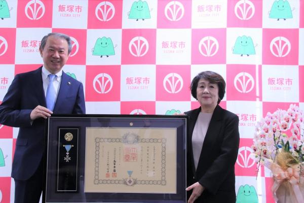 西原眞理子氏と武井市長が「内閣総理大臣感謝状」を前に写真撮影にのぞむ。